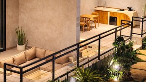 Un intérieur moderne comprenant un canapé, un coin repas et une cuisine.