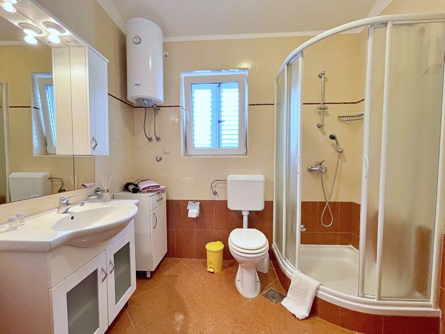 Une salle de bain avec un lavabo, des toilettes et une douche.