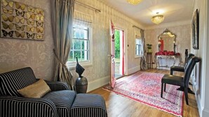 Une pièce avec un canapé à rayures, un lustre et un tapis à motifs.