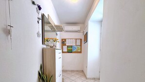 A narrow hallway with a wooden cabinet, a potted plant, and a bulletin board with various notices. - Apartment Car - 90 m from the sea, private terrace, parking, BBQ (Šilo)