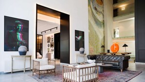 A spacious living area with a modern sofa, a baby crib, and a large rug. - Enjoy Space and Comfort in 2BE in Las Condes (Santiago)