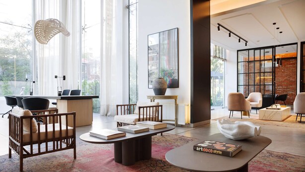 A modern living room with a large window, a coffee table, a sofa, and a bookshelf. - Spacious Apt Retreat in Las Condes Comfort Awaits (Las Condes)