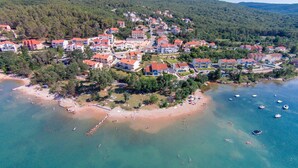 An aerial view of a coastal residential area with houses, a beach, and boats. - Apartment Ivanka - 200 m from sea, close to beach, private parking, terrace (Soline)