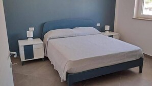 A bedroom with a bed, nightstands, and a window. - Tenuta Nonna Peppa Luxury apartment (Centola)