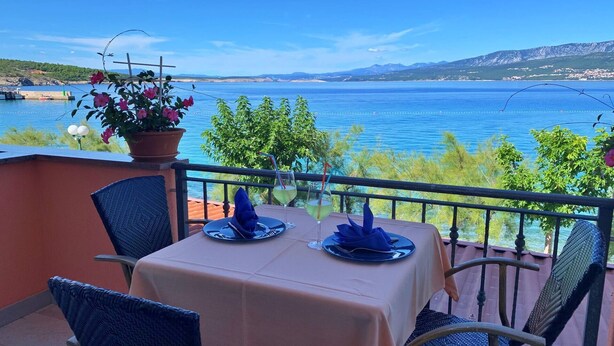 Een tafel voor twee met uitzicht op zee en bergen.