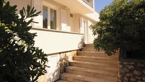 Un bâtiment blanc avec un escalier en pierre menant à un balcon.
