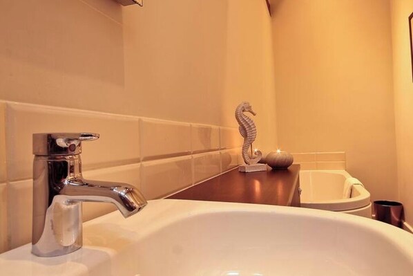 Un baño con lavabo, espejo y bañera.