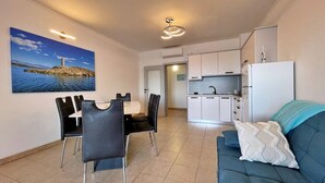 A compact living space with a dining area, kitchenette, and a sofa. - Apartment Neptun - seafront, 20 m from sea, sea view, terrace, private parking (Šilo)