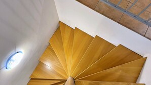 Eine Wendeltreppe mit Holzbodenstufen und einem Metallgeländer.