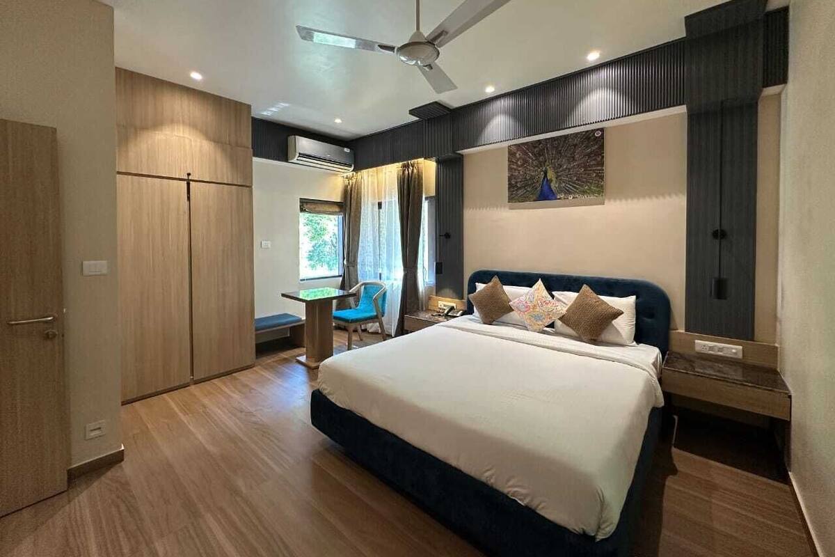 A modern bedroom with a large bed, a desk, and a chair.