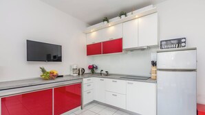 A modern kitchen with white and red cabinets, a built-in oven, and a refrigerator. - Apartment Presker - sea view, modern, 280 m from sea, private terrace, BBQ (Šilo)