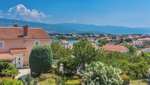 A residential area with terracotta-tiled roofs, a well-maintained garden, and a view of a coastal town in the distance. - Apartment Presker - sea view, modern, 280 m from sea, private terrace, BBQ (Šilo)