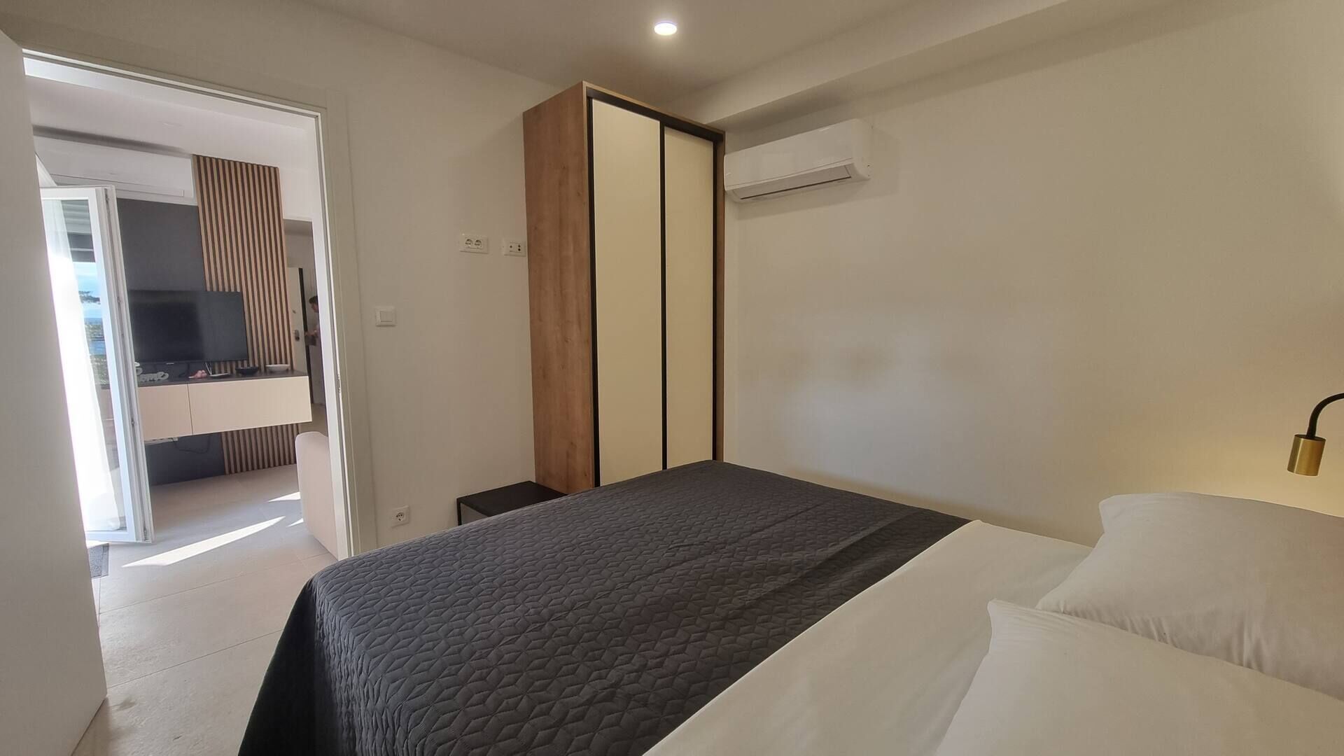 Une chambre à coucher moderne, équipée d’un lit, d’une télévision et d’une armoire.