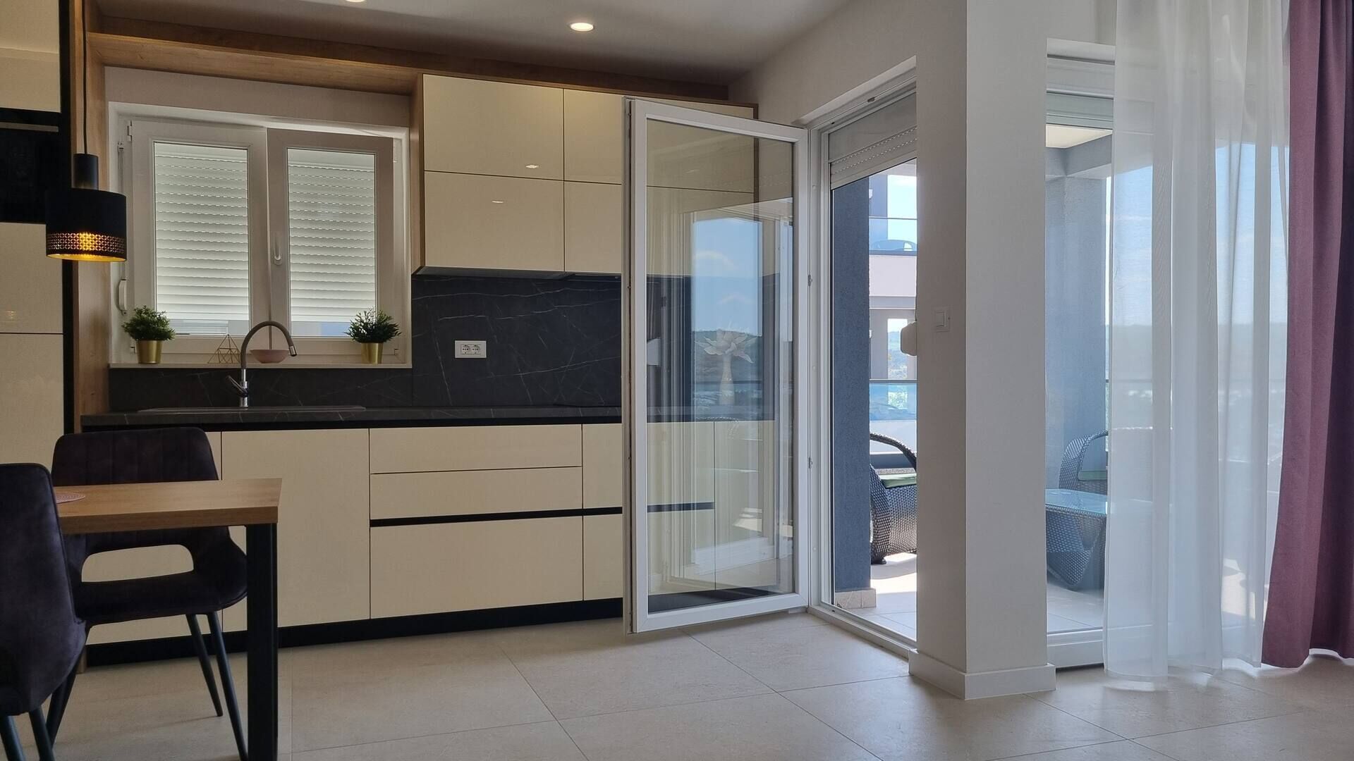 Cozinha moderna com portas deslizantes que dão para uma varanda.