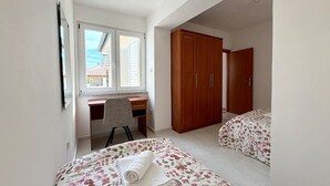 Une chambre avec deux lits, un bureau et une armoire.
