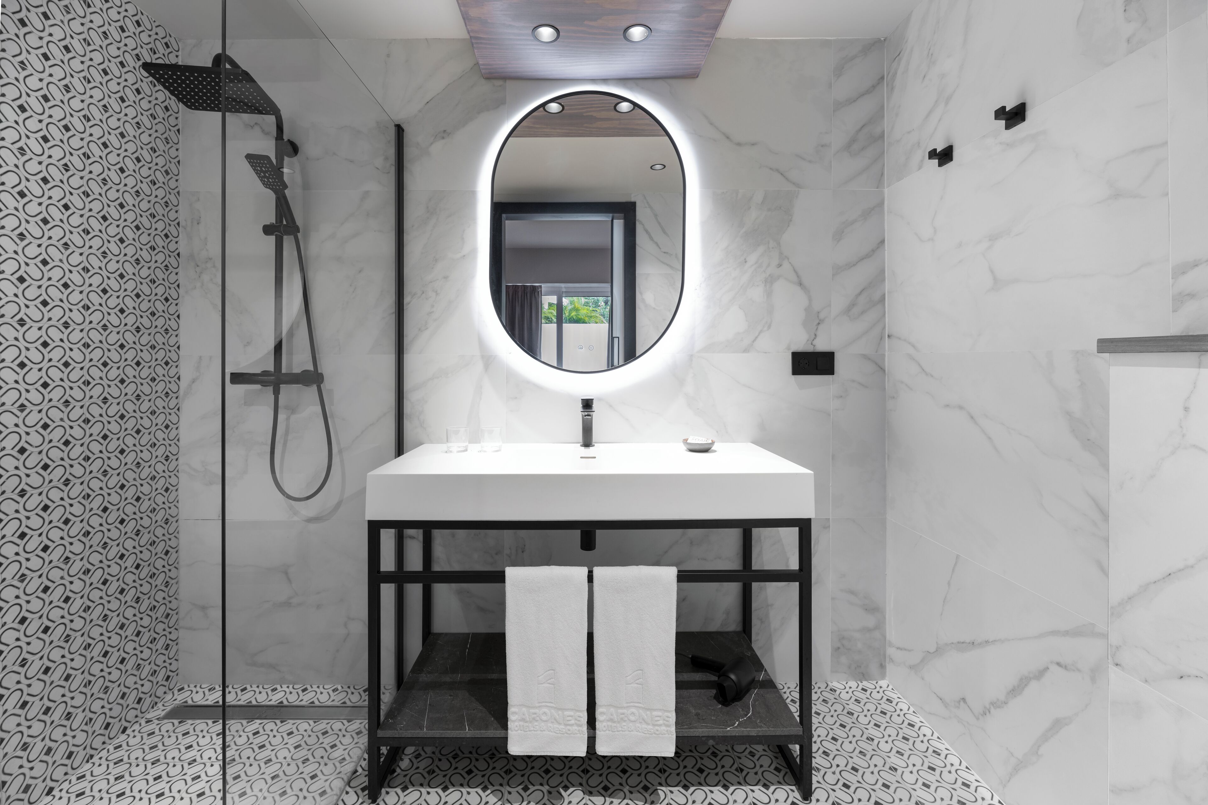 A modern bathroom with a white sink, a mirror, and a shower.