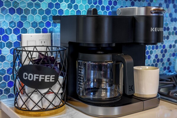 En Keurig-kaffemaskin med en kaffekorg och en mugg placerad på en bänkskiva.