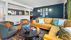Una sala de estar moderna con un sofá, sillones y una mesa de centro.