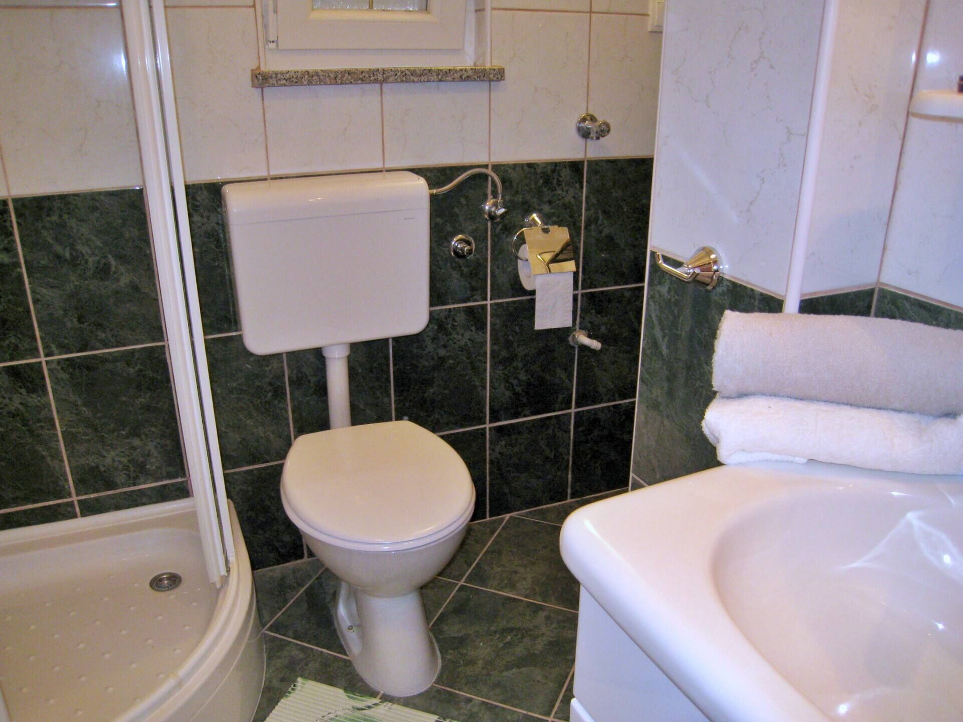 Un baño con inodoro, bañera y ducha.