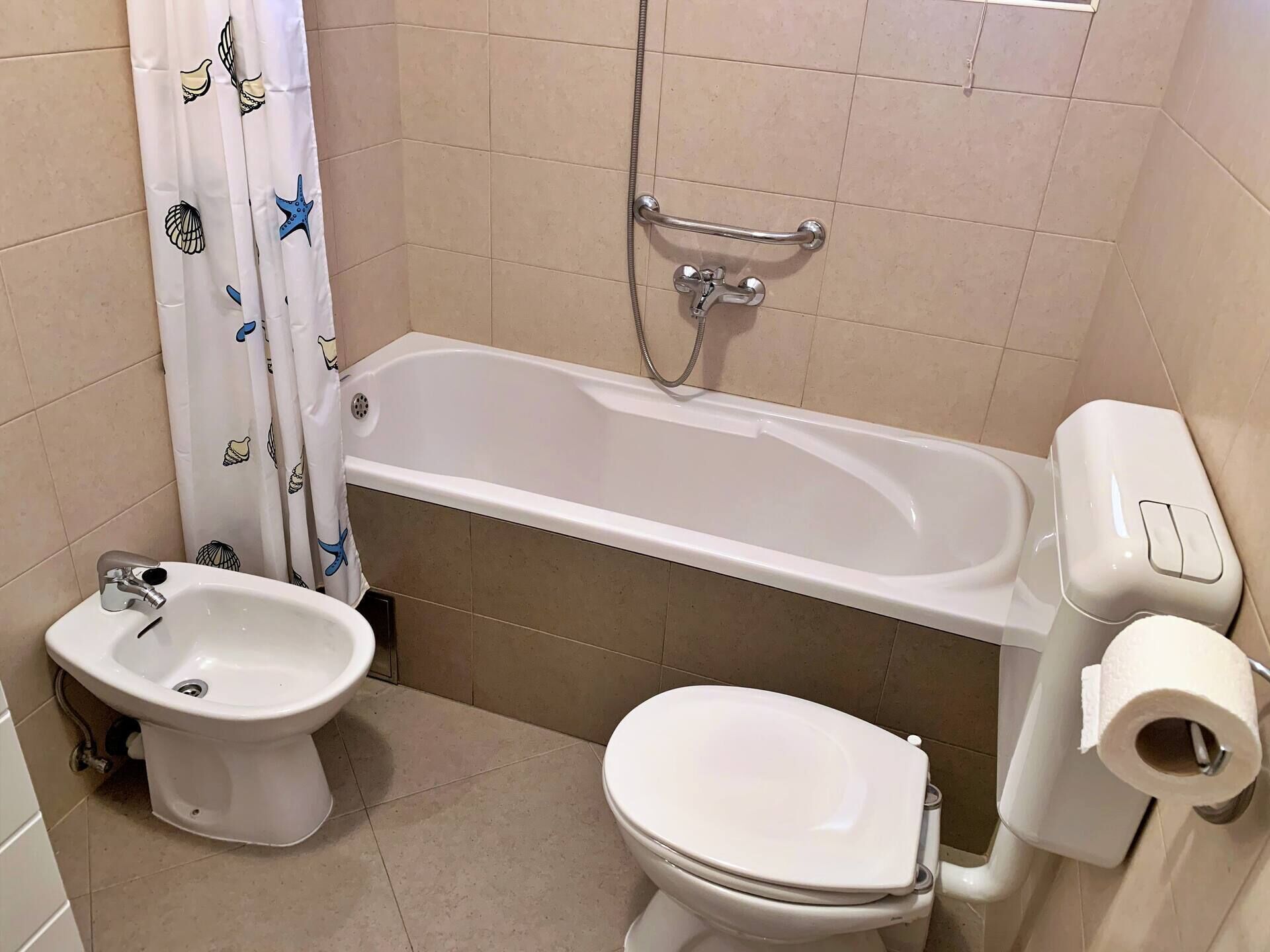 Ein Badezimmer mit Badewanne, Bidet, Toilette und Duschkopf.