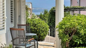 A balcony with a table and chairs, overlooking a scenic view of a body of water and distant mountains. - Apartment Zlatica - 530 m from sea, terrace, BBQ, private parking (Šilo)