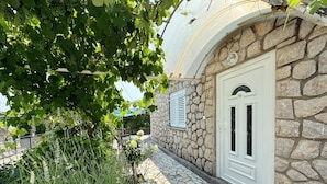 A stone building with a white door and a welcome mat. - Apartment Zlatica - 530 m from sea, terrace, BBQ, private parking (Šilo)