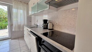 A modern kitchen with a built-in dishwasher, a coffee maker, and a kettle on the counter. - Apartment Zlatica - 530 m from sea, terrace, BBQ, private parking (Šilo)
