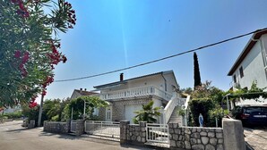 A two-story house with a stone facade, a white balcony, and a gated entrance. - Apartment Zlatica - 530 m from sea, private terrace, garden view, private parking, BBQ (Šilo)