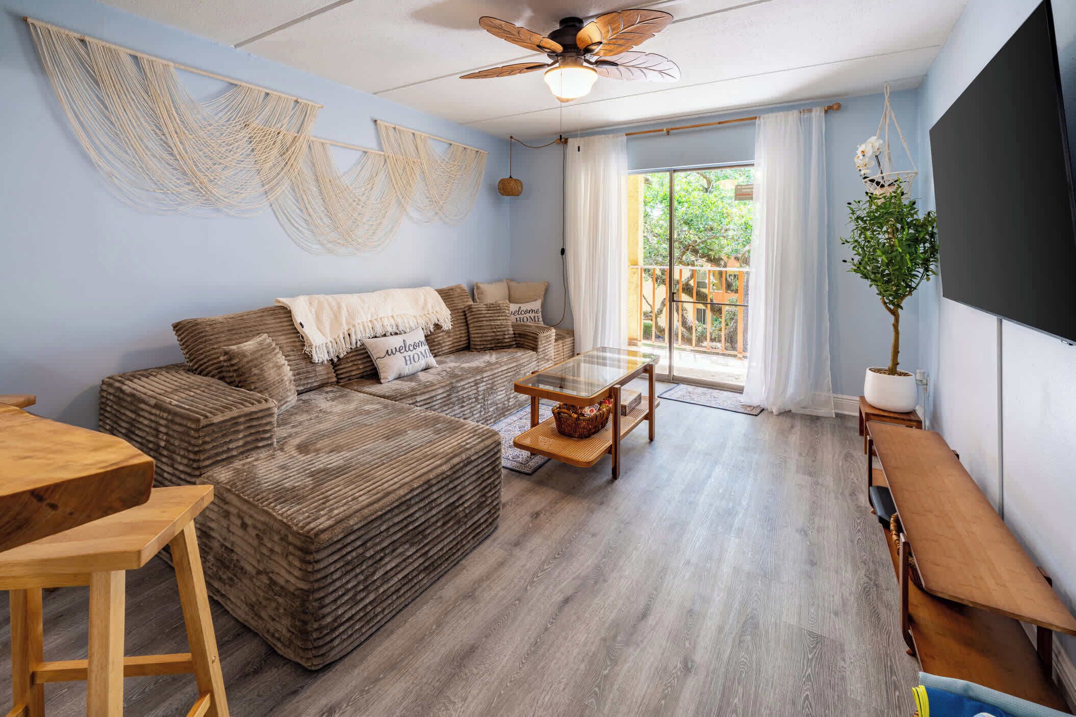 A cozy living room with a sectional sofa, a glass-top coffee table, and a wooden bench.