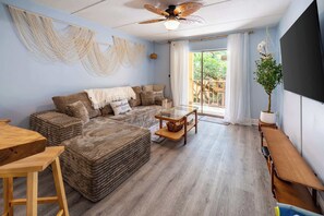 Una sala de estar acogedora con un sofá modular, una mesa de centro de vidrio y un banco de madera.