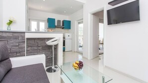 Ein modernes Wohnzimmer mit einem Glastisch, einer Couch und einem Kamin aus Stein.
