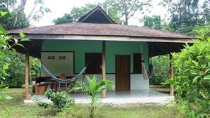 A single-story structure with a tiled roof and a covered porch. - For 5 persons - 300 m from the beach in a tropical garden with biotope. (Cahuita)