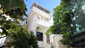 A white building with a balcony, satellite dishes, and a window with shutters. - Apartment Bugi CESTA - with Balcony (Baska)
