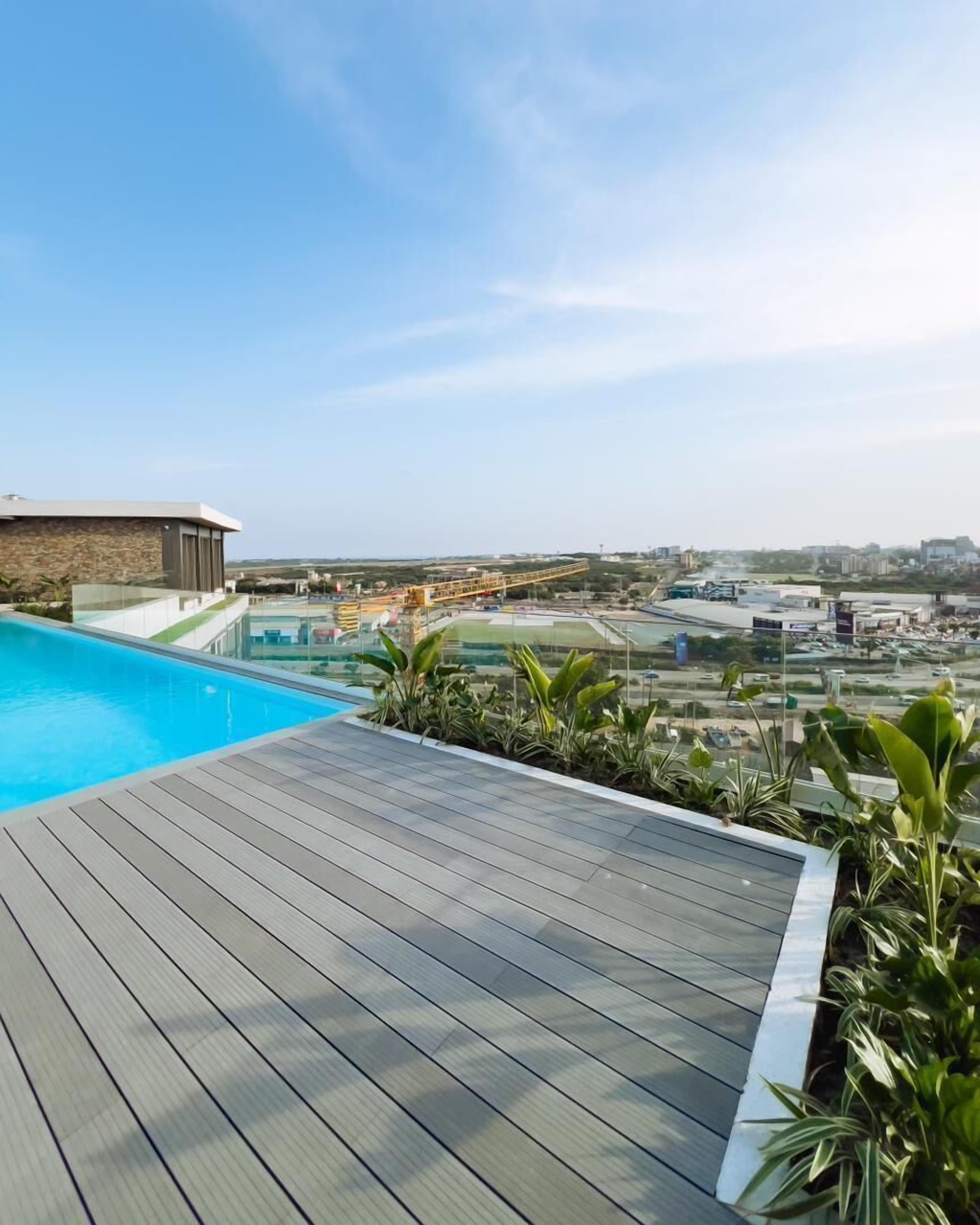 Ein Pool auf dem Dach mit freiem Blick auf die Stadtlandschaft im Hintergrund.