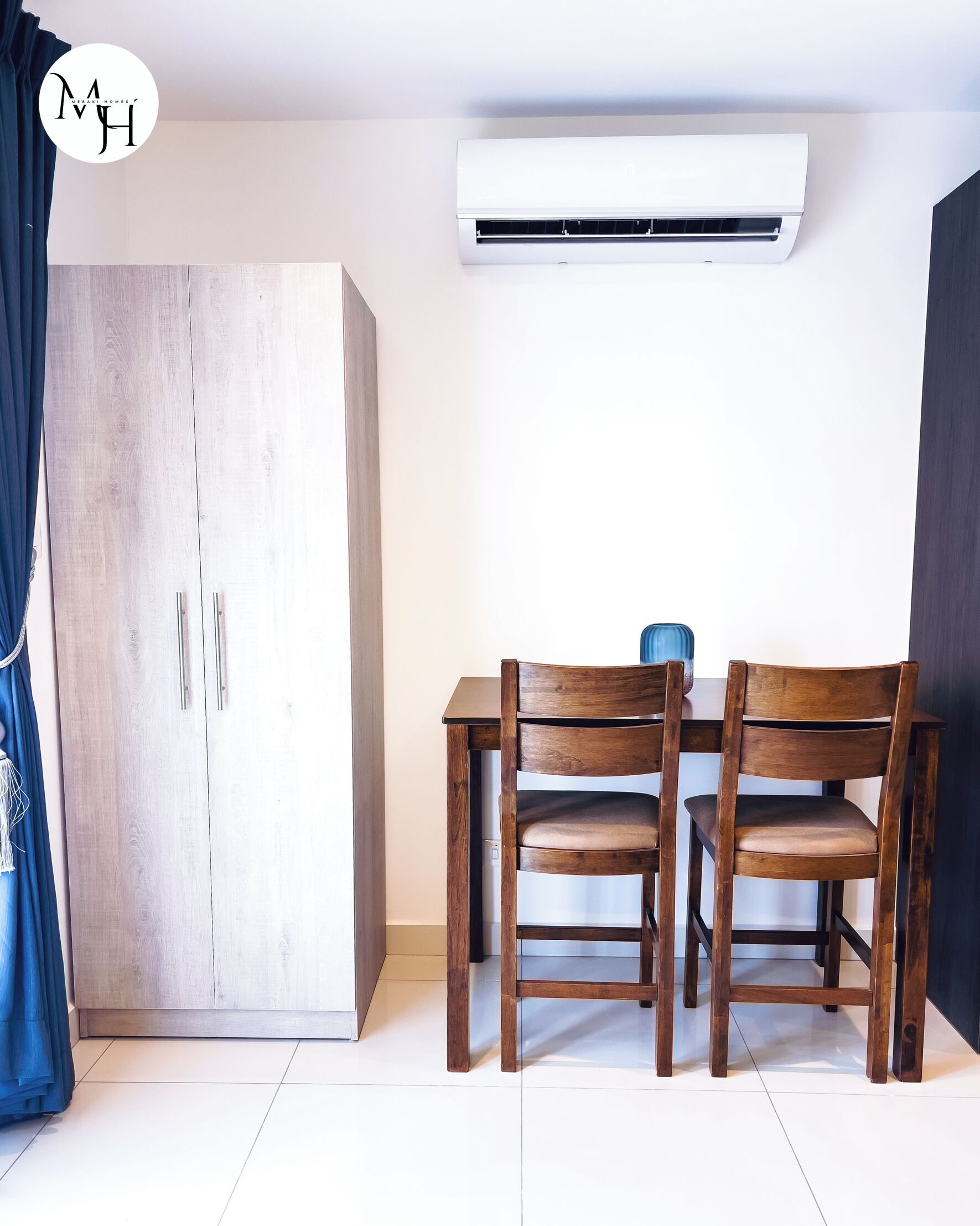 Una habitación con armario, una mesa y dos sillas, y un equipo de aire acondicionado.