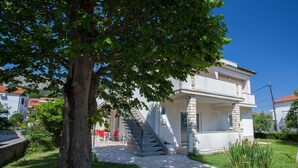 A two-story house with a stone staircase leading to the entrance. - Room Dekanic No.3 - with mini Fridge and Balcony (Baska)