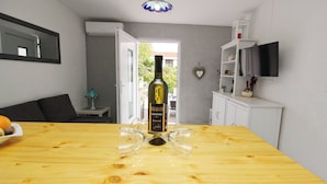 A wooden dining table with a wine bottle and glasses, a television, and a white cabinet. - Apartment Fantov No.1 - with Terrace and BBQ, 250 m from the Beach (Baska)