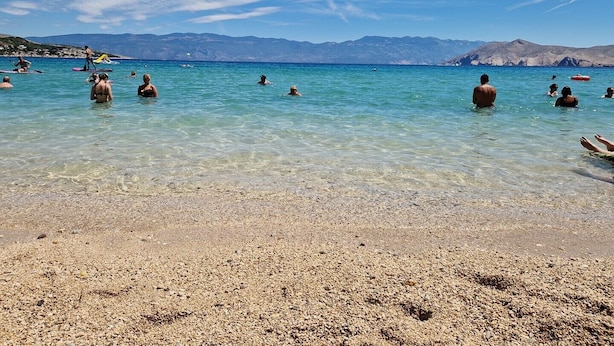 A beach with clear turquoise water, pebbly shore, and distant mountains. - Apartment Fantov No.1 - with Terrace and BBQ, 250 m from the Beach (Baska)