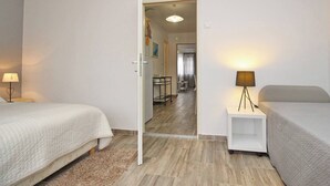 Habitación de hotel con dos camas, una mesita, una lámpara y vistas al comedor.