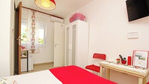 A bedroom with a bed, a desk, a chair, and a wardrobe.