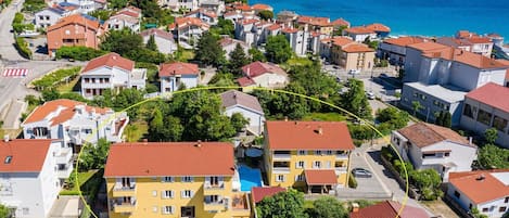 Una zona residencial costera con casas, piscina y vista al mar.