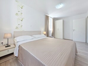 Une chambre d’hôtel comprenant un lit, une table de chevet, une lampe et un élément décoratif mural.