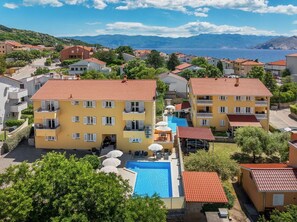 Un quartier résidentiel doté d’une grande piscine, de nombreux balcons et offrant une vue sur la mer.