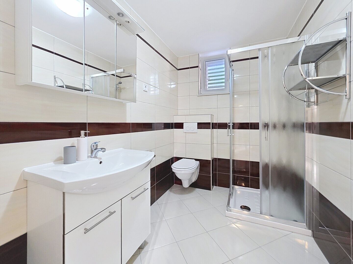 A modern bathroom with a glass shower enclosure, a white sink, and a toilet.