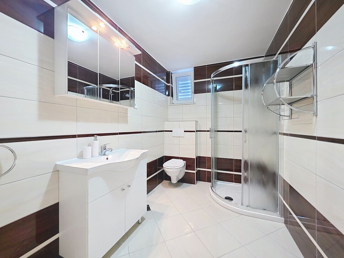 A modern bathroom with a glass shower enclosure, a white sink, and a toilet.