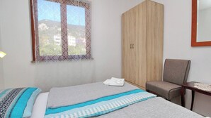 Une chambre à coucher avec un lit, une armoire, une chaise et une petite table.
