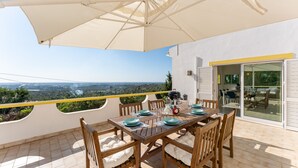A terrace with a table set for four, overlooking a scenic landscape. - Casa Federica | 4 Bedrooms | Magnific Views | Loulé (Santa Bárbara de Nexe)