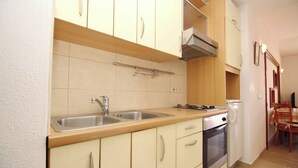 A compact kitchen with two sinks, a stove, and a built-in oven. - Apartment Mrkus brdo - with Balcony, near the Beach (Baska)