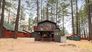 A cabin with a balcony, surrounded by tall trees. - Charming Cabin Escape (Big Bear Lake)