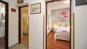 Una habitación de hotel con cama, mesita de noche y un cuadro en la pared.